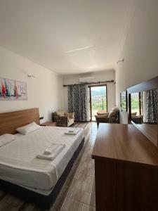 a bedroom with a large bed and a large window at sandhill otel in Kemer