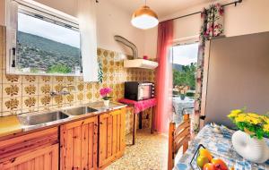 a kitchen with a sink and a window and a table at Arilena Studios in Paralia Saranti