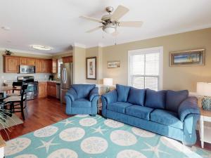 a living room with blue couches and a kitchen at Silver Shores Unit 8 in Tybee Island