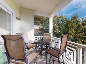 a patio with a table and chairs on a balcony at Silver Shores Unit 8 in Tybee Island