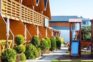 a sidewalk next to a building with bushes at Sunrise-Sarbinowo domki i apartamenty in Sarbinowo
