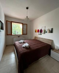 una camera da letto con un letto e due asciugamani di A casa de lu Gio a SantʼAndrea