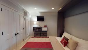 um quarto com uma cama e uma televisão na parede em Suite Escape em Savannah