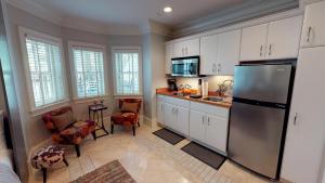 uma cozinha com armários brancos e um frigorífico de aço inoxidável em Suite Escape em Savannah