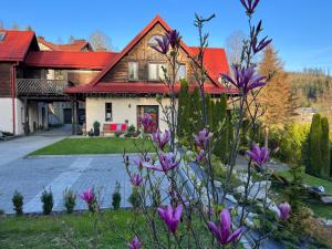 dom z czerwonym dachem i fioletowymi kwiatami w obiekcie Villa Good Time w Wiśle