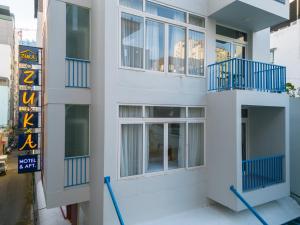 een wit gebouw met blauwe balkons erop bij Zuka Hotel & Apartment in Da Nang