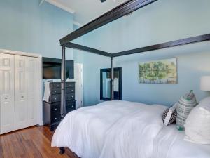 - une chambre avec un lit blanc et un mur bleu dans l'établissement Broughton Retreat, à Savannah