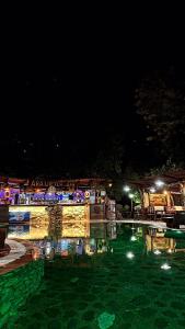 uma piscina à noite com luzes na água em Ara E Vjeter Resort em Velipojë