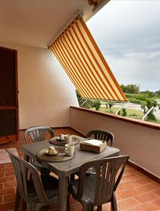 un tavolo e sedie su un balcone con una grande finestra di A casa de lu Gio a SantʼAndrea