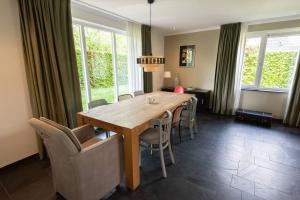 a dining room with a wooden table and chairs at Grote vakantiewoning 190m2! op ruim- en groen perceel in Otterlo