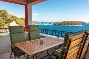 Apartment Cerin Prizba في Blato: طاولة وكراسي على شرفة مطلة على المحيط
