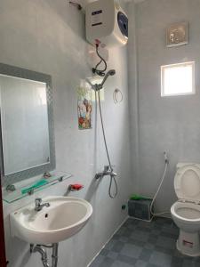 a bathroom with a shower and a sink and a mirror at Nhà Nghỉ Relax Cảnh Dương in Lang Co