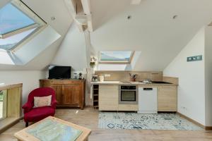 an attic kitchen with a red chair and a table at Coquet T2. Exceptionnel entre lac et montagnes in Menthon-Saint-Bernard