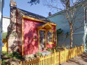 a small red house with a yellow fence at Tiny House in Savannah