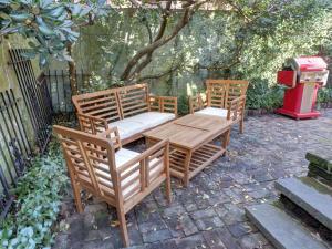 drie houten stoelen en een tafel en een vuilnisbak bij Tiny House in Savannah