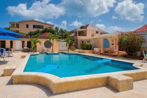 a large swimming pool in a yard with a house at Breeze by the sea in Five Islands Village