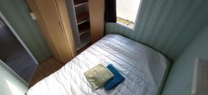 - un petit lit dans une petite chambre avec fenêtre dans l'établissement Domek nad Zalewem, à Grudki