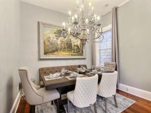 uma sala de jantar com uma mesa e um lustre em Southern Hall Estate em Savannah