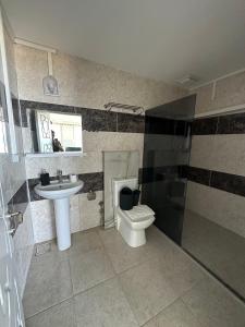 a bathroom with a toilet and a sink at sandhill otel in Kemer