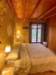 a bedroom with a large bed in a stone wall at Villa Paola in Villa San Leonardo