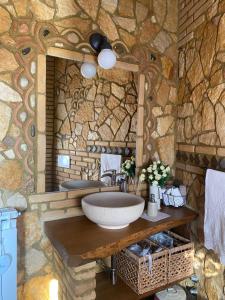 a bathroom with a sink and a stone wall at Villa Paola in Villa San Leonardo