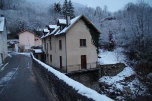 a house with a snow covered roof next to a road at Prés de Luchon, Maison Moderne 