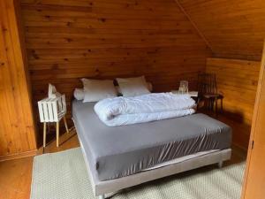 a bed in a room with a wooden wall at Prés de Luchon, Maison Moderne 