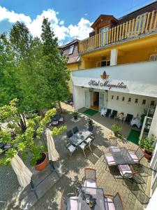 una vista aérea de un patio con sillas y mesas en Hotel Magnólia, en Balatonszepezd