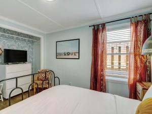 a bedroom with a bed and a tv and a window at Walking on Sunshine in Tybee Island