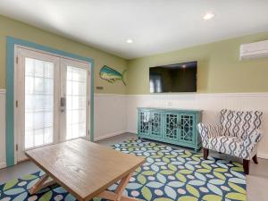 uma sala de estar com uma mesa e uma cadeira em Tybee Tyme Lower em Tybee Island