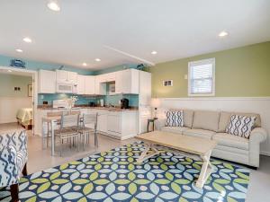 a living room with a couch and a table and a kitchen at Tybee Tyme Lower in Tybee Island