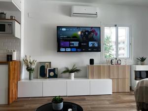 a living room with a tv on a white wall at Lux Apartment BY NAMASTE ELITE in Torremolinos