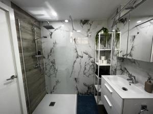 a white bathroom with a shower and a sink at Lux Apartment BY NAMASTE ELITE in Torremolinos +43 photos