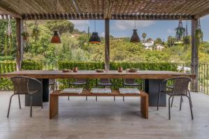 un patio con grande tavolo e sedie in legno di Golf a Santa Cristina d'Aro