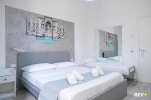 ローマにあるヴィアレ ジュリオ チェザーレ ゲストハウスの白い部屋のベッド2台 白い枕付