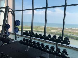 een fitnessruimte met uitzicht op de oceaan vanuit een raam bij lmperio Residence Melaka - Private Indoor Hot Jacuzzi in Melaka
