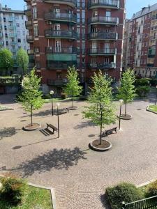 a park with trees and benches in front of a building at Casa dei Fiordalisi in Milan