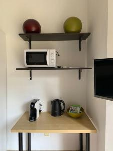 a table with a microwave and a bowl of fruit at Casa dei Fiordalisi in Milan