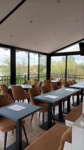 - une salle à manger avec des tables, des chaises et des fenêtres dans l'établissement Navigator, à Palić