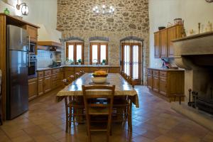 a large kitchen with a table and a fireplace at Mas Solés in Parlavà