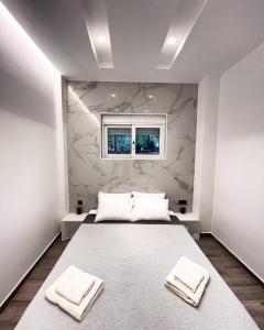 a bedroom with a bed with two towels on it at Luxury Black and White Interior Apartments in Kalamata