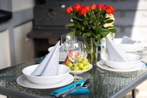 stół z talerzami i okularami oraz wazon kwiatów w obiekcie Domki Apartamentowe - Na Makowej w Jastrzębiej Górze