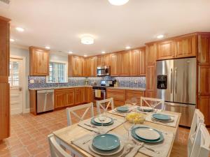 een keuken met houten kasten en een tafel met borden erop bij Sundial Inn Unit 2 in Tybee Island