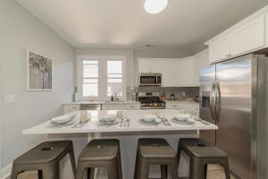 a kitchen with a large island with stools and a refrigerator at Urban Oasis in beautiful East Rock Free Parking Yale adjasent in New Haven