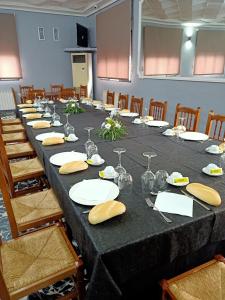 a long table with plates and wine glasses on it at Restaurante & Hostal El Volante in Moraleja