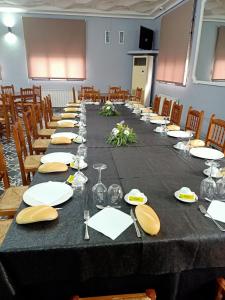 uma mesa longa com pratos, copos e guardanapos em Restaurante & Hostal El Volante em Moraleja