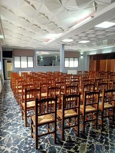 um quarto com filas de cadeiras de madeira em Restaurante & Hostal El Volante em Moraleja