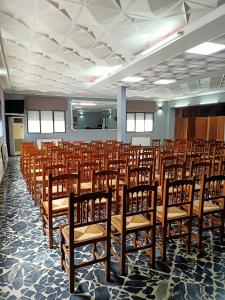 a room with rows of wooden chairs in it at Restaurante & Hostal El Volante in Moraleja