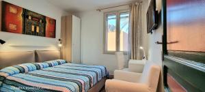 チェファルにあるVilla Vittoriaのベッド1台、椅子2脚、窓が備わる客室です。