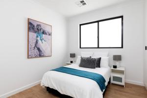 Habitación blanca con cama y ventana en Luxury private ensuite room close to Airport,City, Genelg Beach, en Plympton